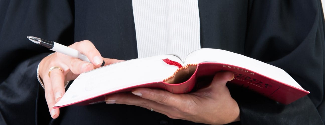 Avocat tenant un livre juridique, représentant la consultation préventive.