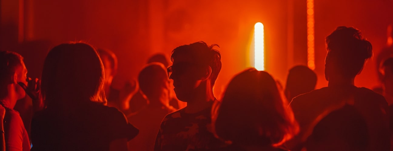 silhouettes de personnes dans une boîte de nuit éclairée en rouge