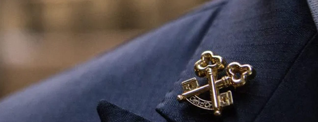 Zoom sur l’insigne Clefs d’Or épinglé sur une veste bleue