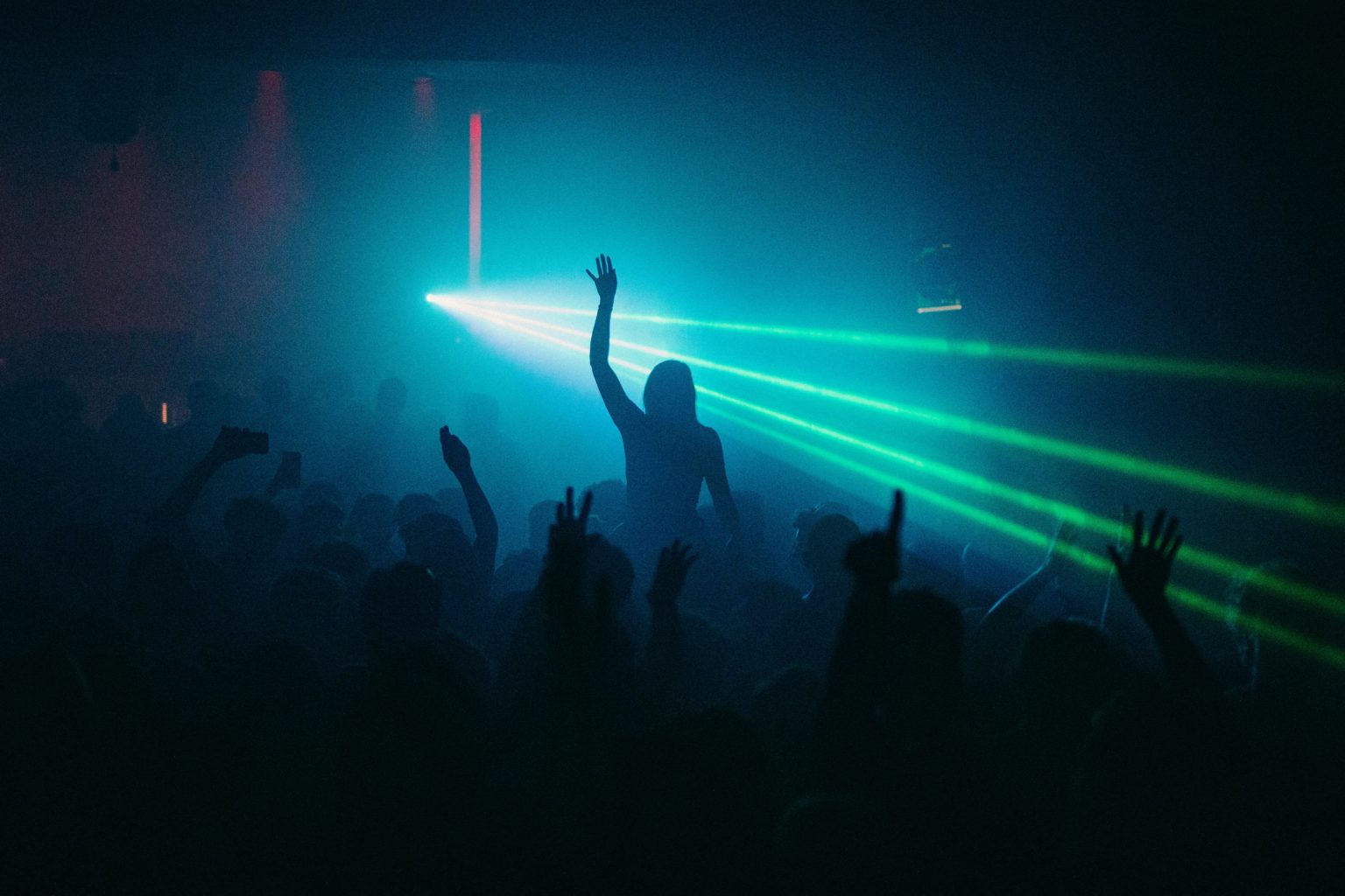 foule dansante sous des lasers bleus lors d'une soirée bruxelloise