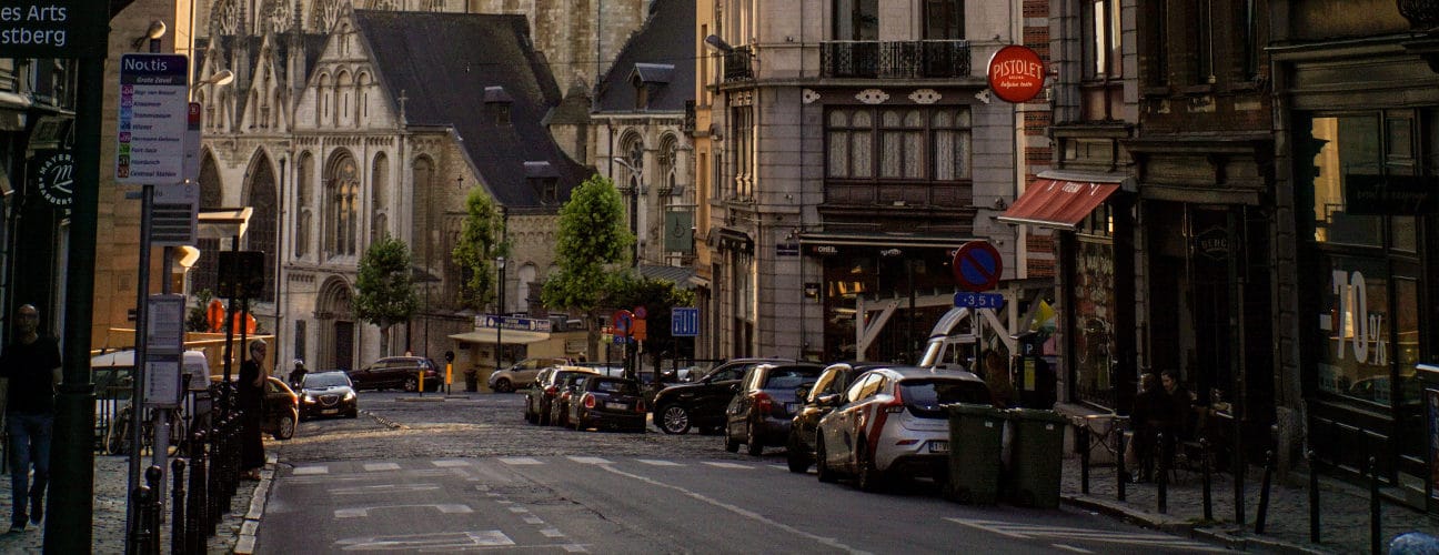 Rue commerçante à Bruxelles avec magasins et voitures